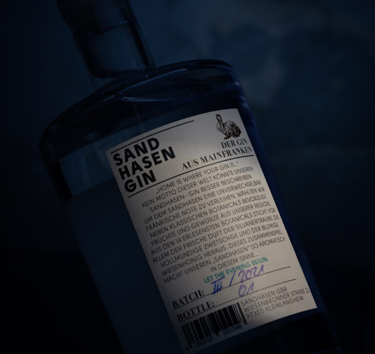 Sandhasen Gin Flasche vor einem dunklem blauem Hintergrund.